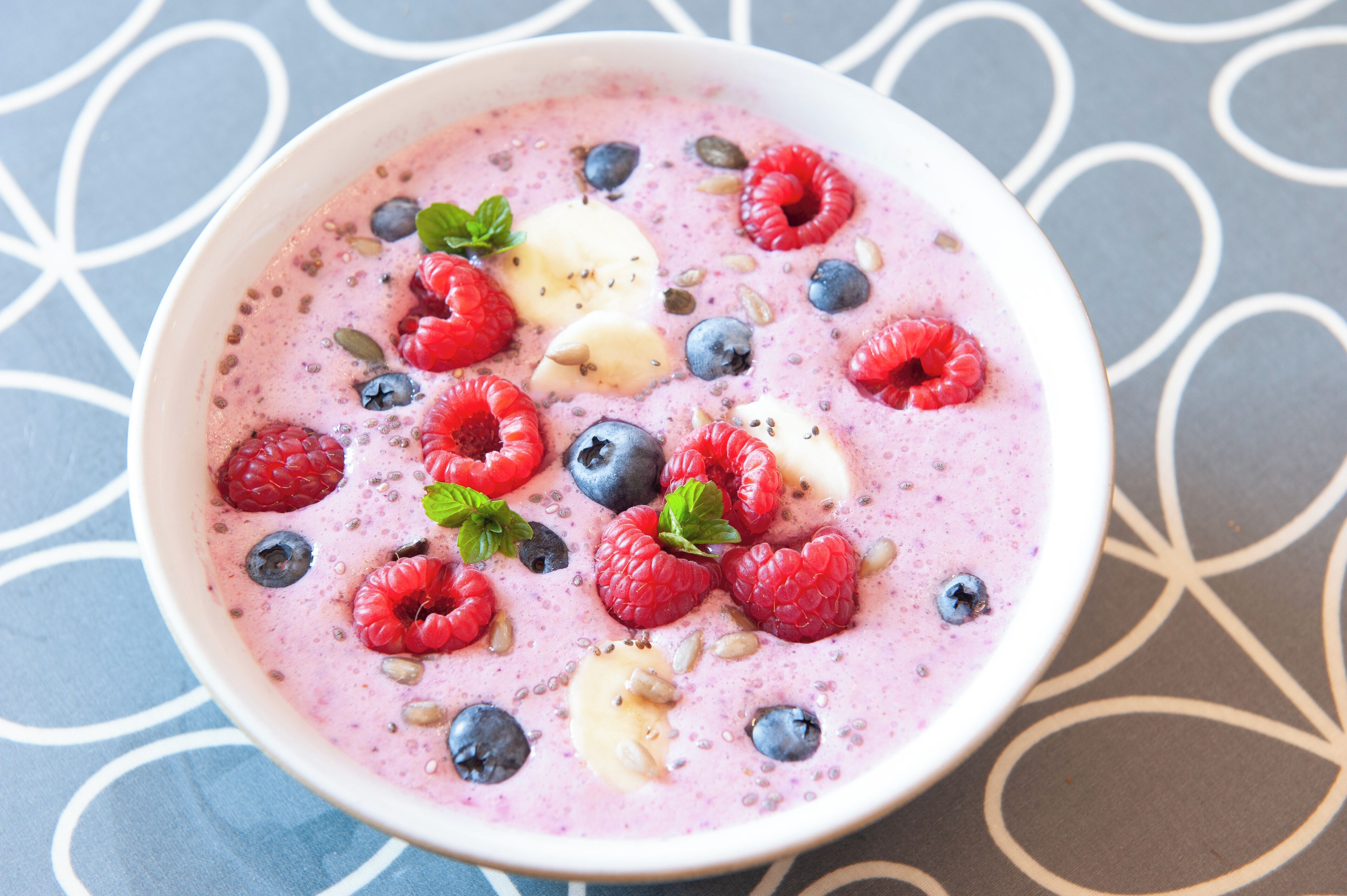 Un bol de smoothie contenant diverses baies et graines.