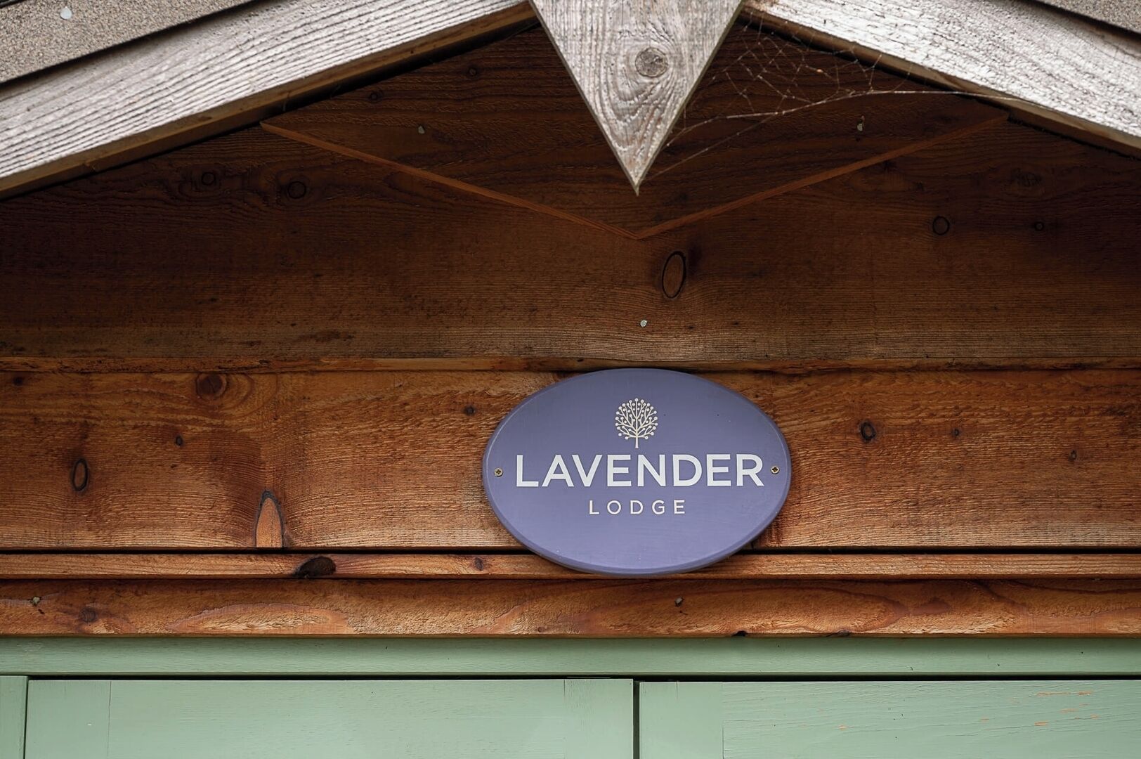 En träkonstruktion med en skylt som det står ”LAVENDER LODGE” på.