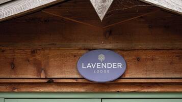 En träkonstruktion med en skylt som det står ”LAVENDER LODGE” på.