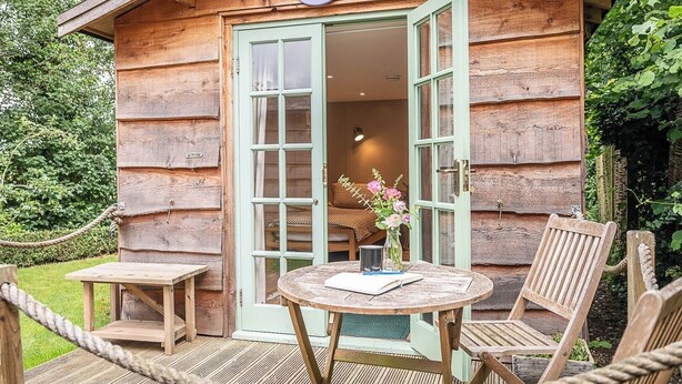 Une cabane en bois sur laquelle est accrochée une enseigne indiquant « LAVENDER LODGE ».