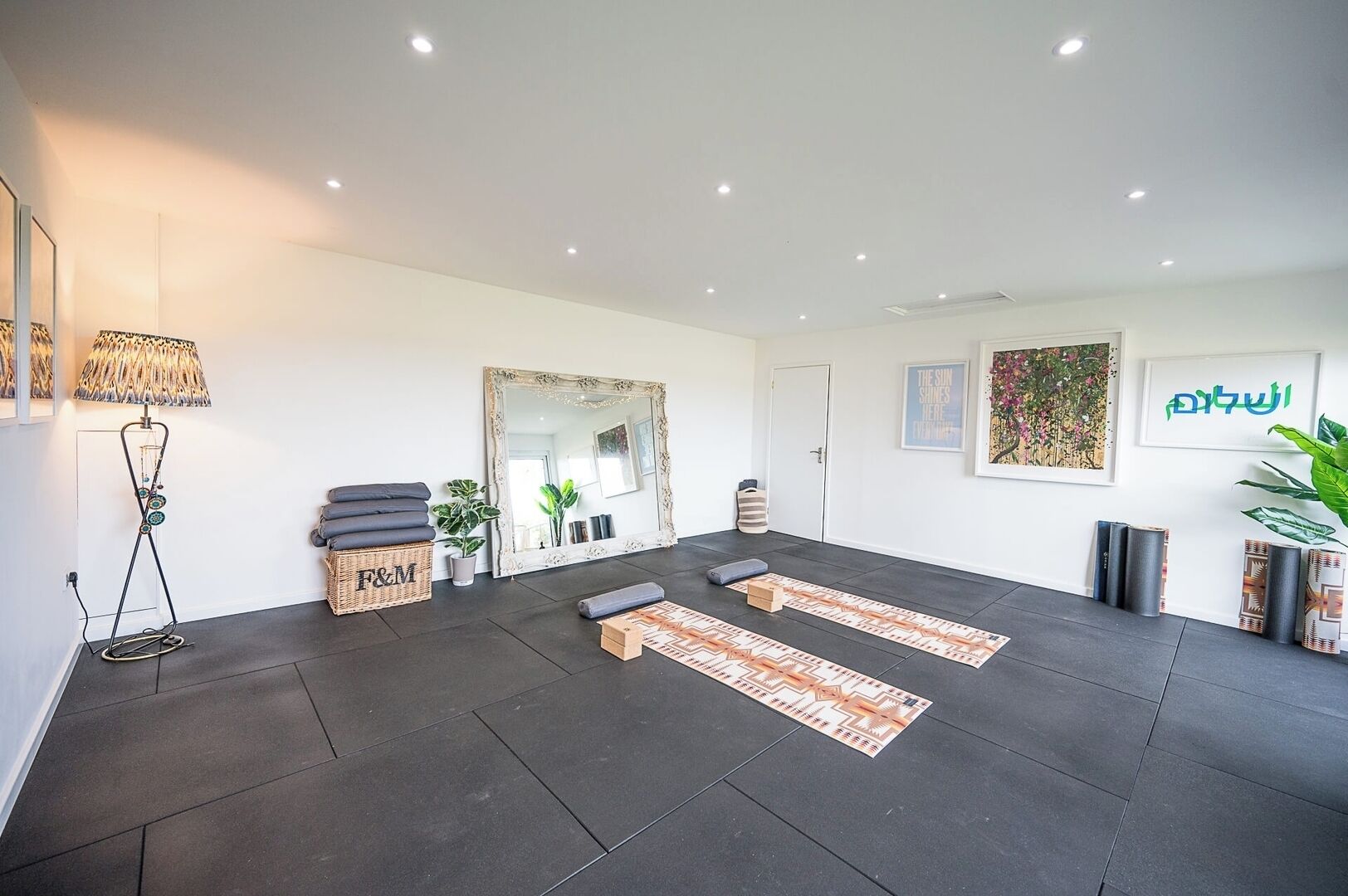 A room with a large mirror, a standing lamp, and a patterned rug.