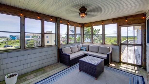 A covered porch with a sectional sofa, a small table, and a potted plant. - 5813- Crowe's Nest, South Nags Head with Private Pool, Pool Table and Ocean View...Family Fun! (Nags Head)