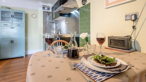A dining table set with a plate of salad, wine glasses, and a pitcher of water.