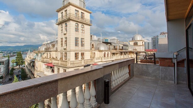 A building with a dome and a balcony overlooking a cityscape. - Memory Hotel Batumi (Batumi)