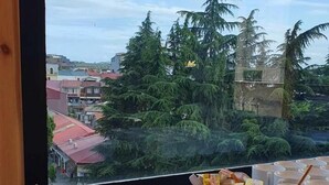 A buffet table with various food items and a view of a cityscape through a window. - Memory Hotel Batumi (Batumi)
