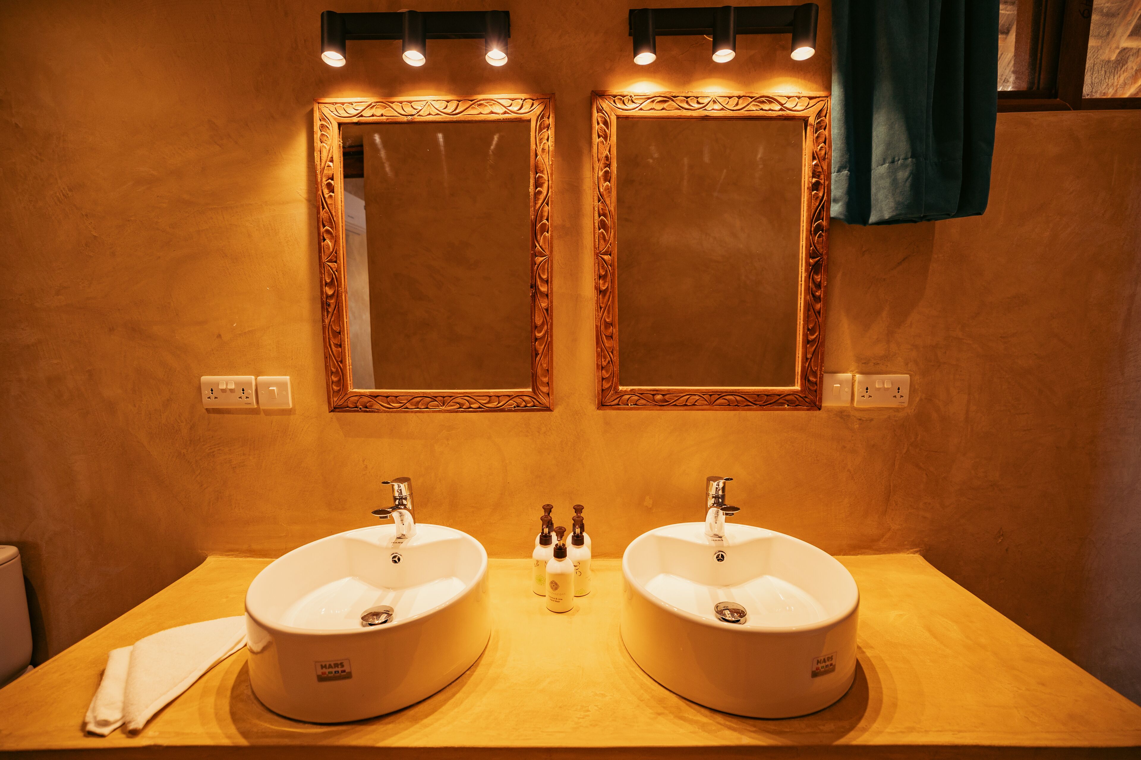 Un bagno con due lavandini, un asciugamano e uno specchio.