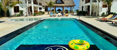 Un resort con piscina, edificios de techo de paja y un cartel que dice "MAYAI OCEAN RESORT".