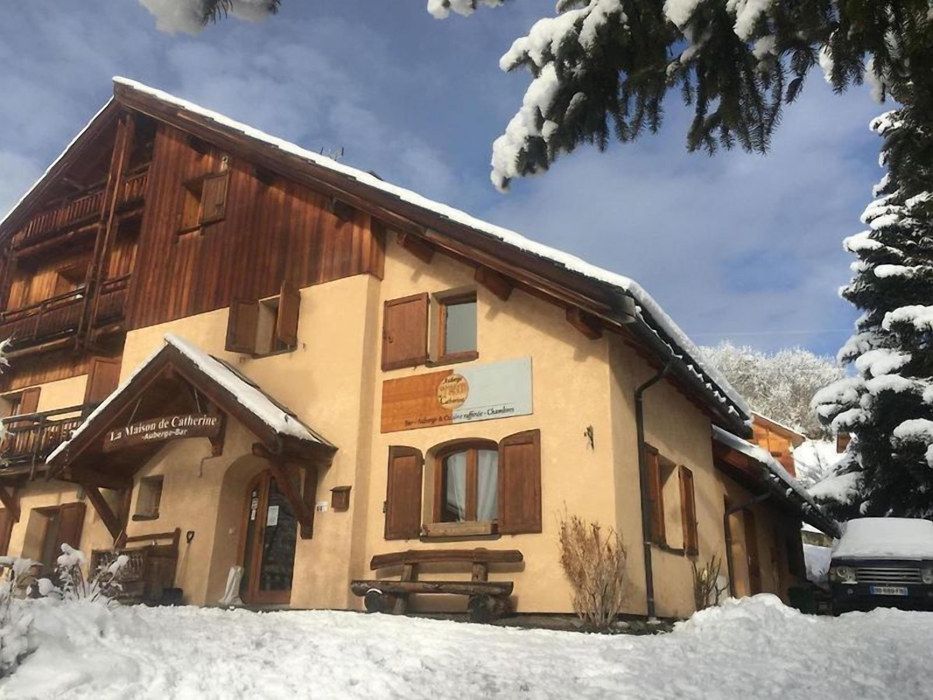 Un edificio de estilo chalé con fachada de madera y tejado cubierto de nieve.