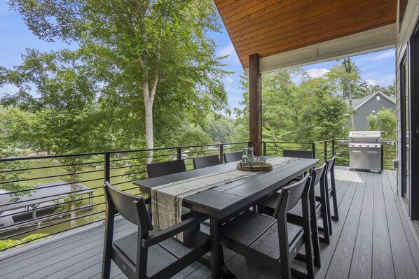 A deck with a table and chairs, overlooking a lake and trees. - Entertain, Enjoy Friends and Family - amazing amenities inc hot tub! (Catawba)