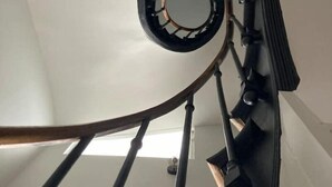 A spiral staircase with a metal handrail and a glass enclosure at the top. - Maison Gabriel Appartement Bulle (Abbeville)