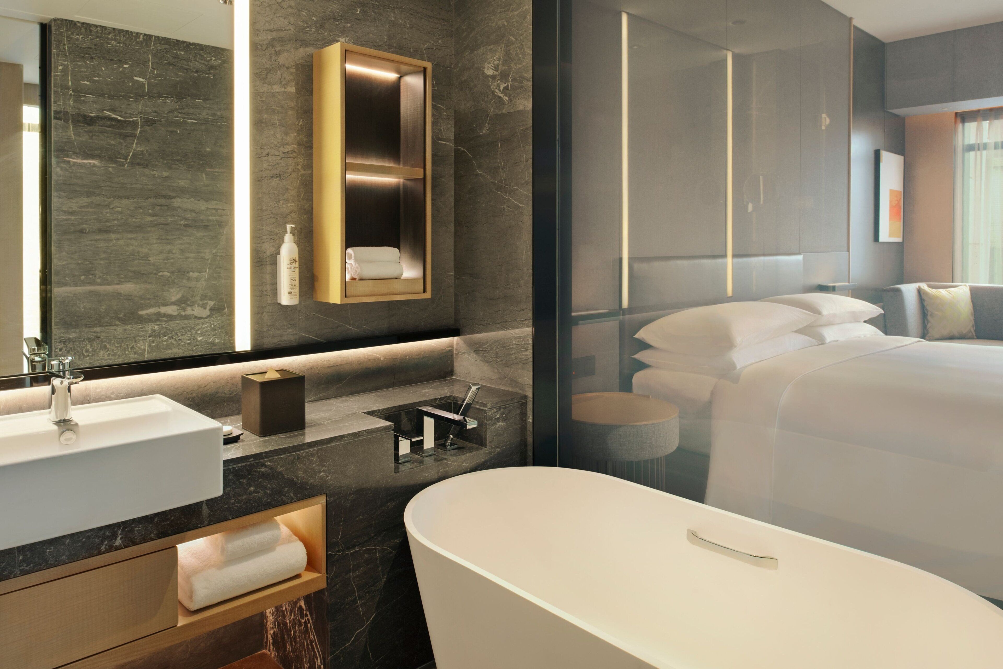 A modern bathroom with a large bathtub, a vanity with a sink, and a mirror.