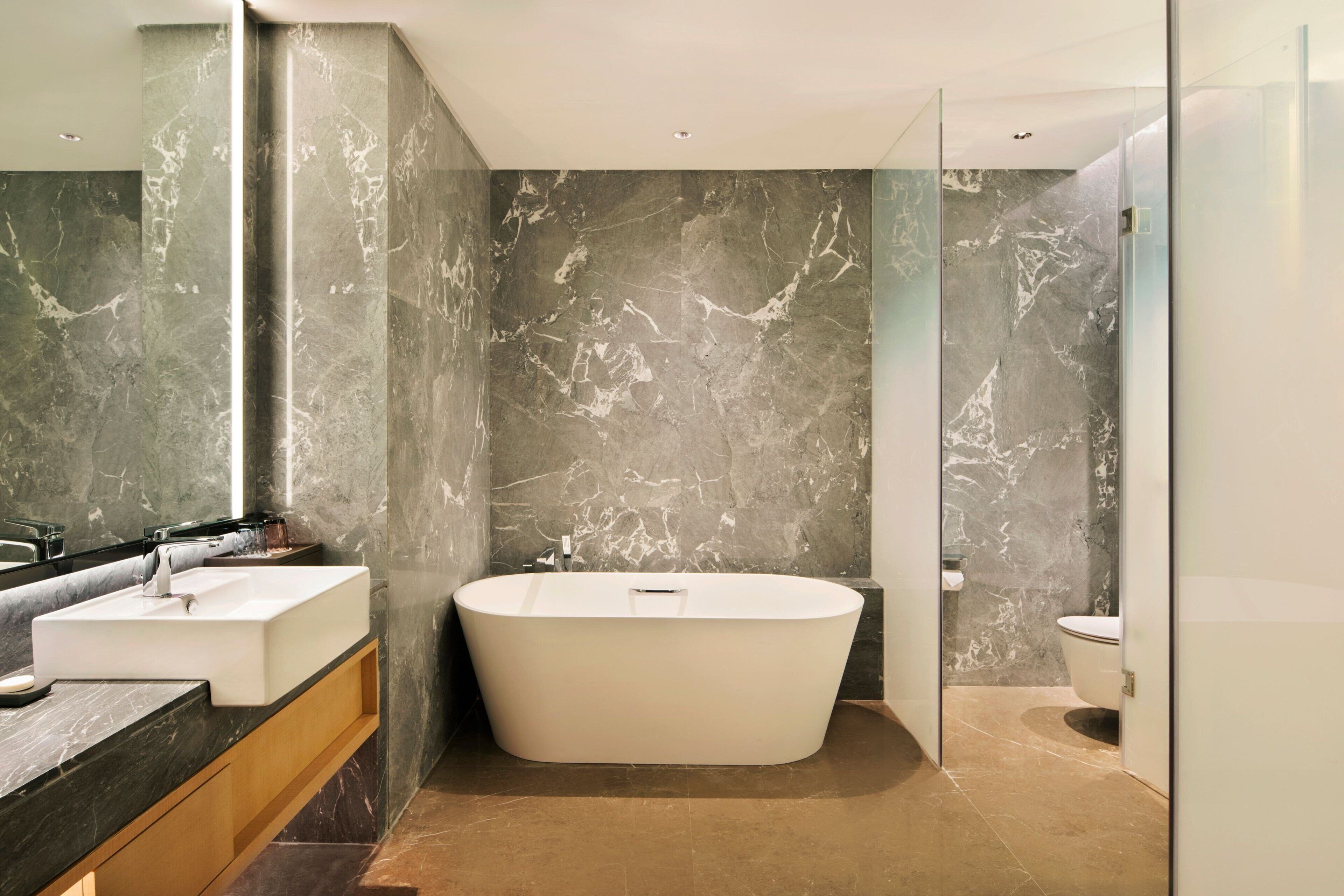A modern bathroom with a freestanding bathtub, a vanity with a sink, and a toilet.