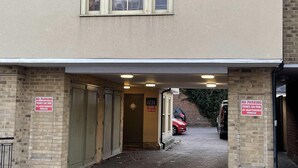 Ein Gebäude mit überdachter Einfahrt und zwei Verbotsschildern.