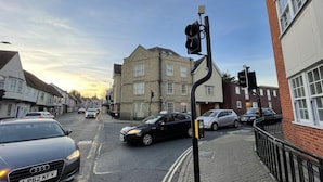 Straßenansicht mit Gebäuden, Autos und einer Ampel.