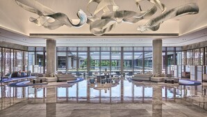 A spacious lobby with a reflective floor, large windows, and modern seating arrangements. - Crowne Plaza Ganzhou by IHG (Ganzhou)