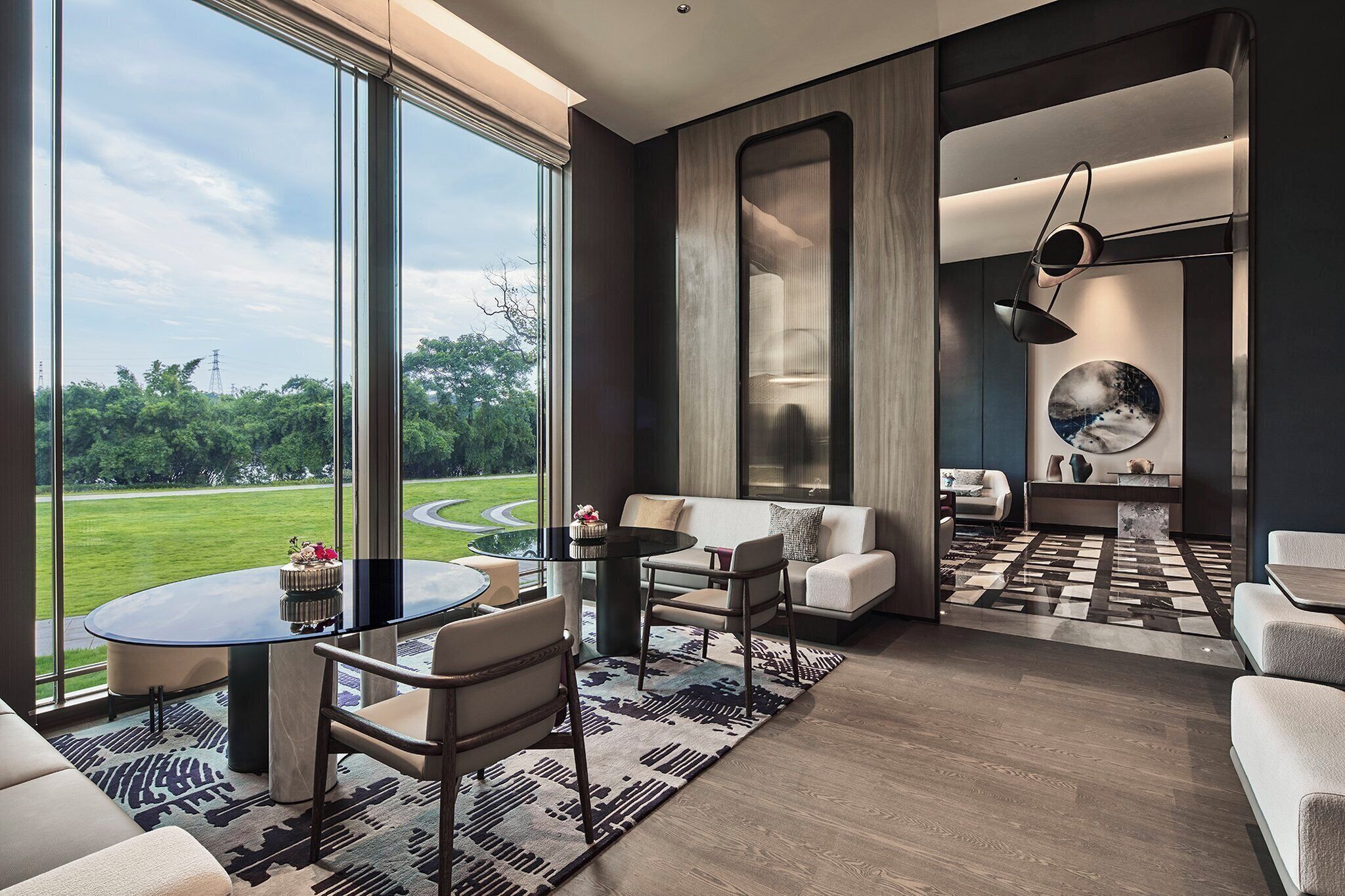 A modern living room with a large window, a round coffee table, and a sofa.