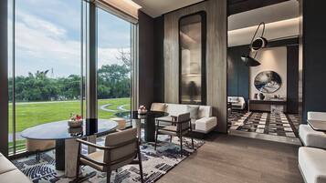 A modern living room with a large window, a round coffee table, and a sofa.