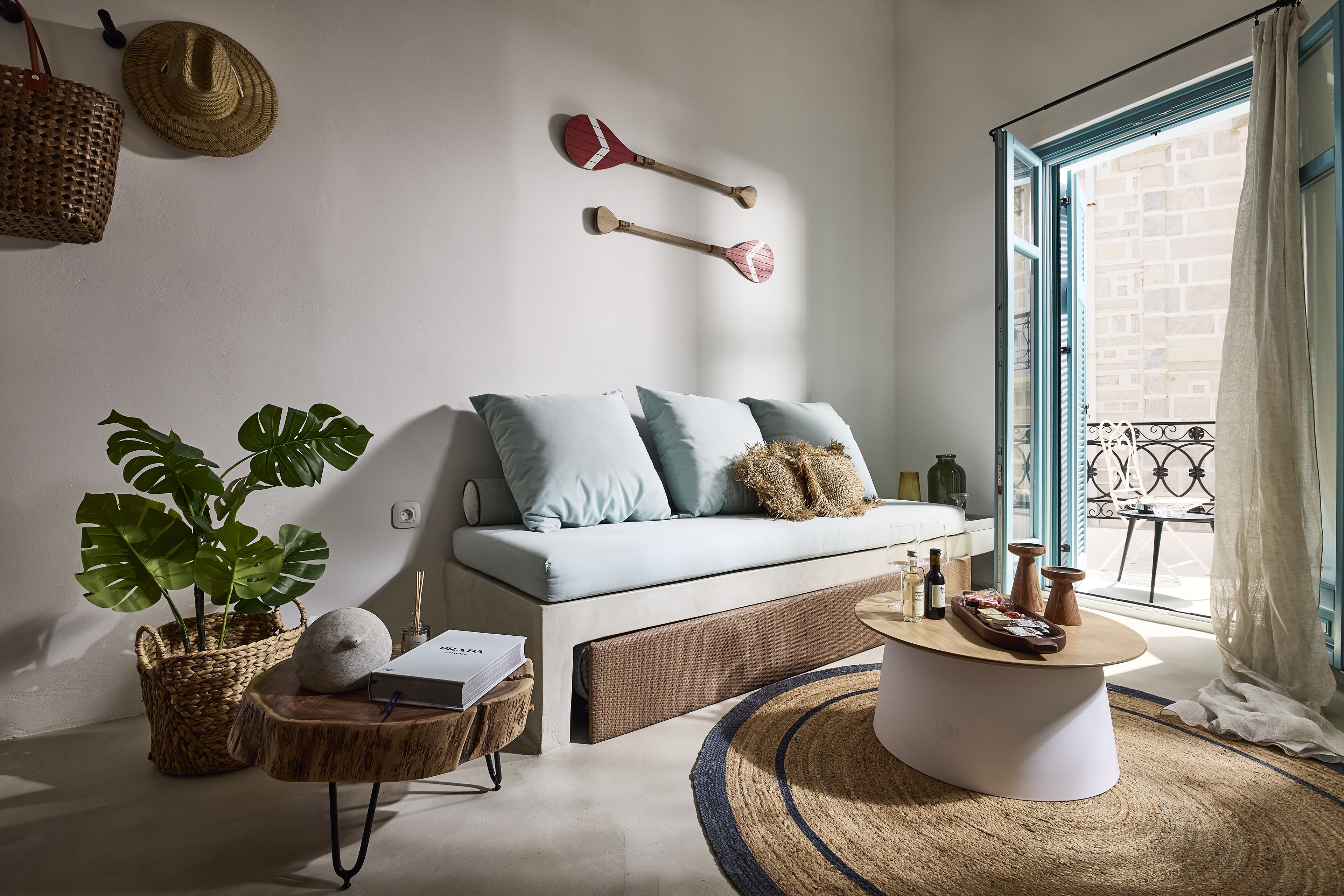 A modern living room with a light blue sofa, a round coffee table, and a large potted plant.