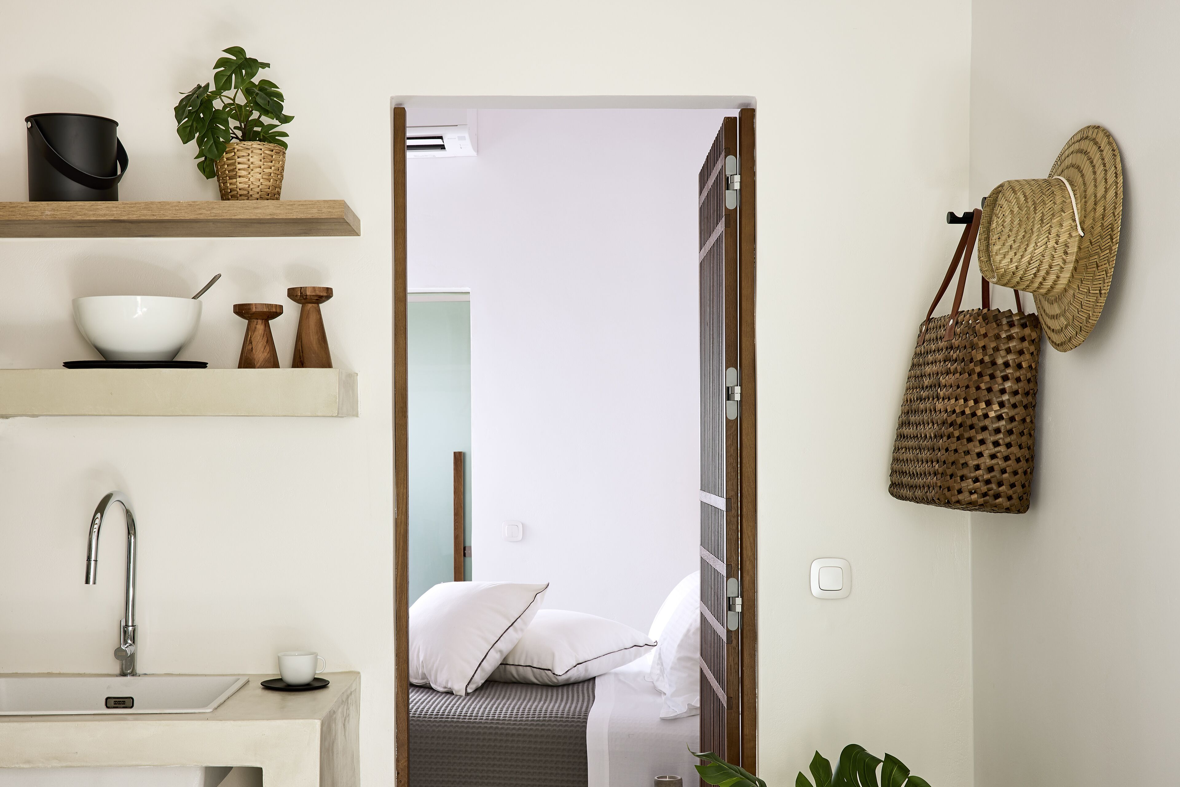 A modern bathroom with a white sink, a mirror, and a shower area.