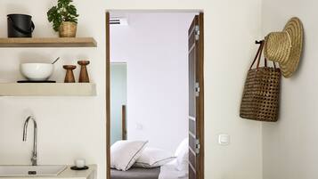 A modern bathroom with a white sink, a mirror, and a shower area.