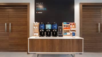En kaffestation med flere kaffemaskiner og et skilt, der står 'MUST. HAVE. COFFEE. EXPRESS'.