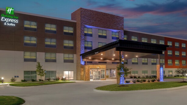 A Holiday Inn Express & Suites building with a modern design, featuring a covered entrance and a landscaped area with trees. - Holiday Inn Express and Suites Alton St Louis Area by IHG (Alton)