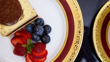 Um prato com uma fatia de cheesecake, mirtilos e morangos.