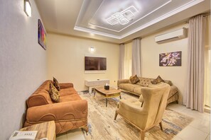 Suite Deluxe, 1 llit de matrimoni, microones, vistes a la ciutat | Sala d'estar | Televisor intel·ligent de 46 polzades amb canals per cable i Netflix 