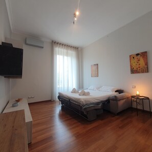 A bedroom with a bed, bedside table, and a TV mounted on the wall. - BnButler - Venini 14 (Milan)
