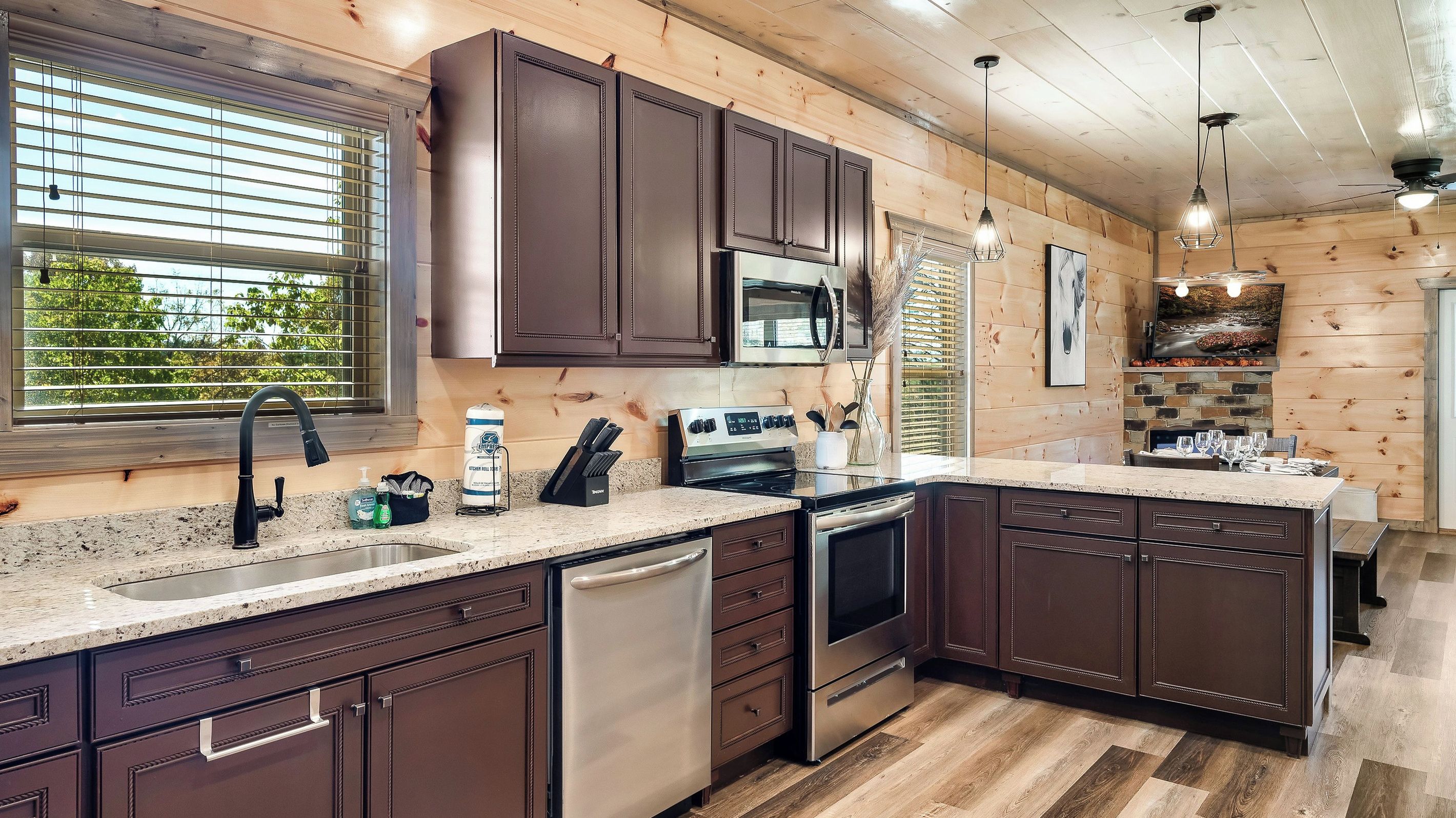 Une cuisine moderne avec des meubles en bois foncé, des appareils électroménagers en acier inoxydable et un plan de travail en granit.