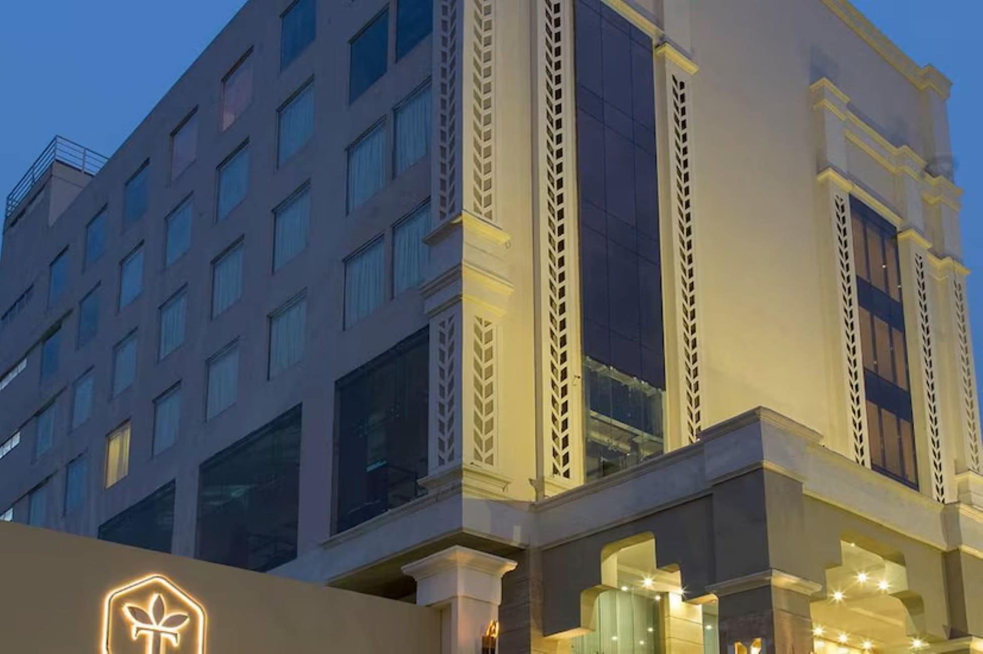 Un hotel de varios pisos con un diseño arquitectónico moderno, que cuenta con ventanas amplias y columnas decorativas.