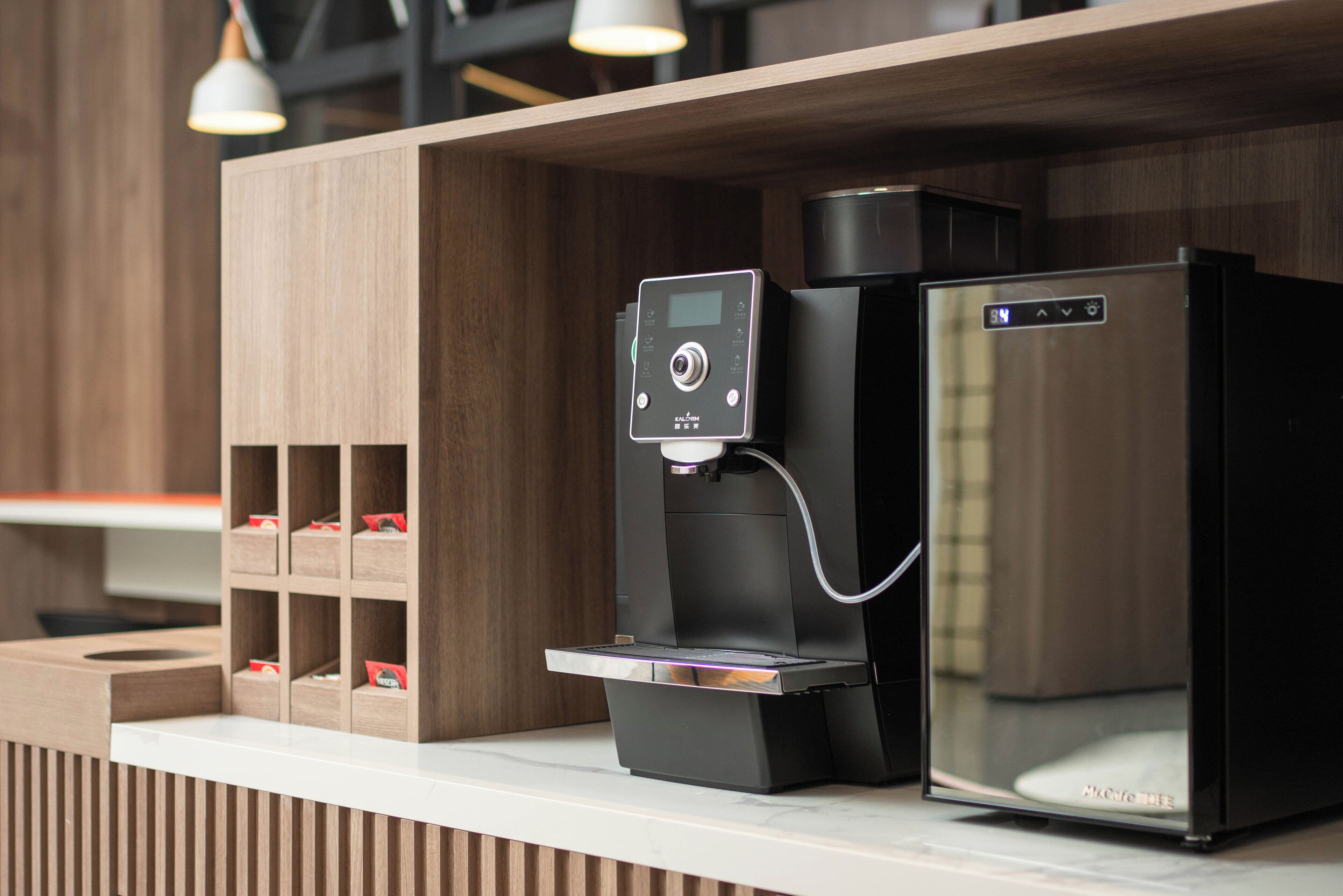 A coffee machine with a digital display and a water dispenser on a counter.