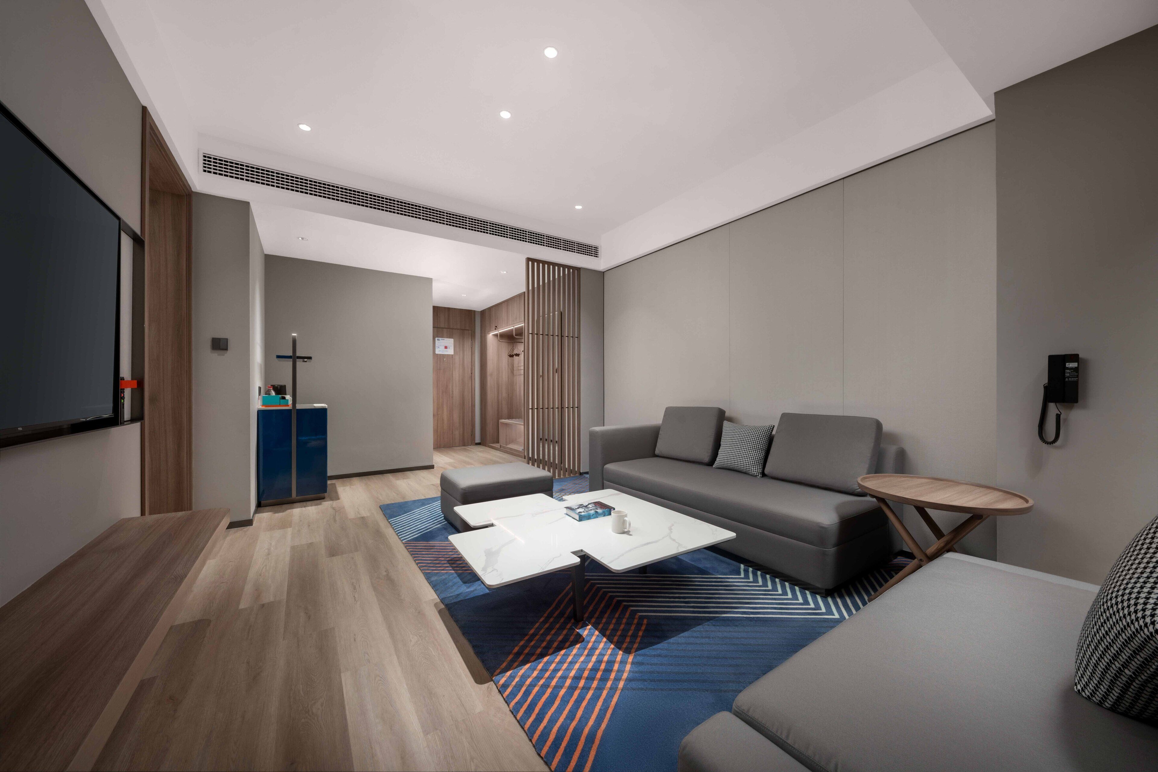 Una sala de estar moderna con sofá, mesa de centro y una mesita auxiliar.