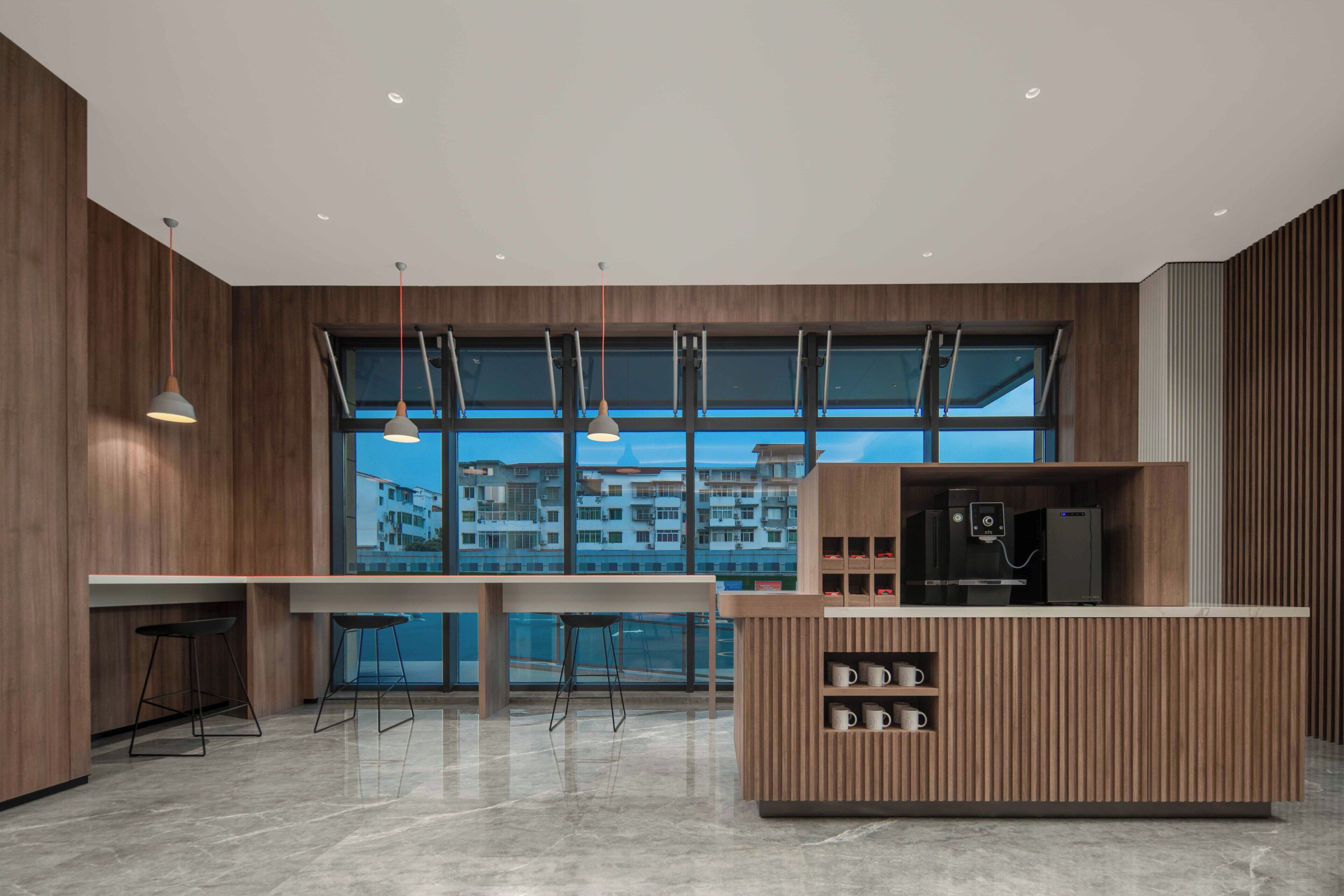 Une cuisine moderne dotée d’une grande fenêtre, de meubles en bois et d’un coin bar.