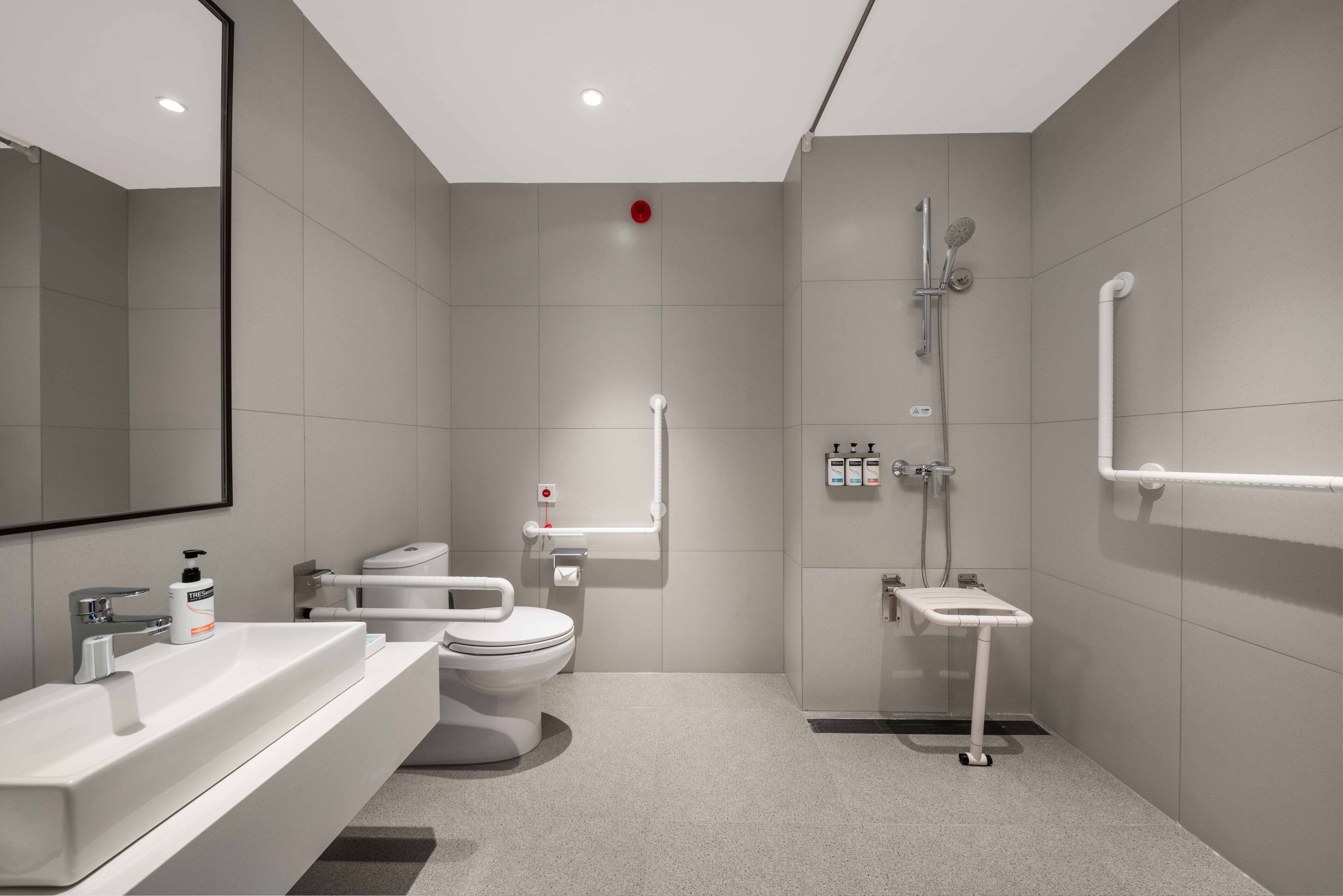 A modern bathroom with a white sink, toilet, and shower.