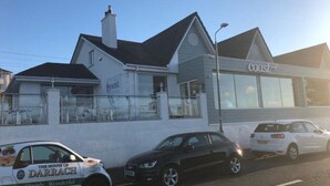 Un edificio con un letrero que dice 'coast' y un coche estacionado adelante.