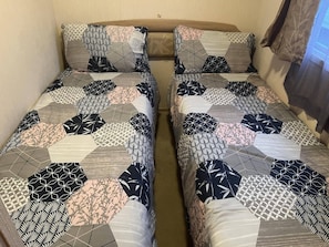 A double bed with a geometric patterned bedspread and matching pillows.