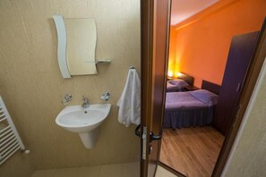 A bathroom with a sink, mirror, and towel rack.