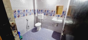 Un baño con inodoro, lavamanos y ducha.