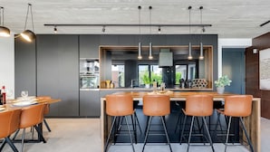 A modern kitchen with a central island, bar stools, and pendant lighting. - Villa Marli ZadarVillas (Zaton)