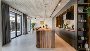 A modern kitchen with a wooden island, dark cabinetry, and a large window. - Villa Marli ZadarVillas (Zaton)