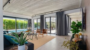 A modern living room with a pool view, large windows, and a minimalist design. - Villa Marli ZadarVillas (Zaton)