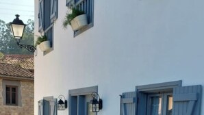 A building with multiple windows, some with shutters, and a door with a small porch area. - Rural cottage in Riocorvo (riocorvo)