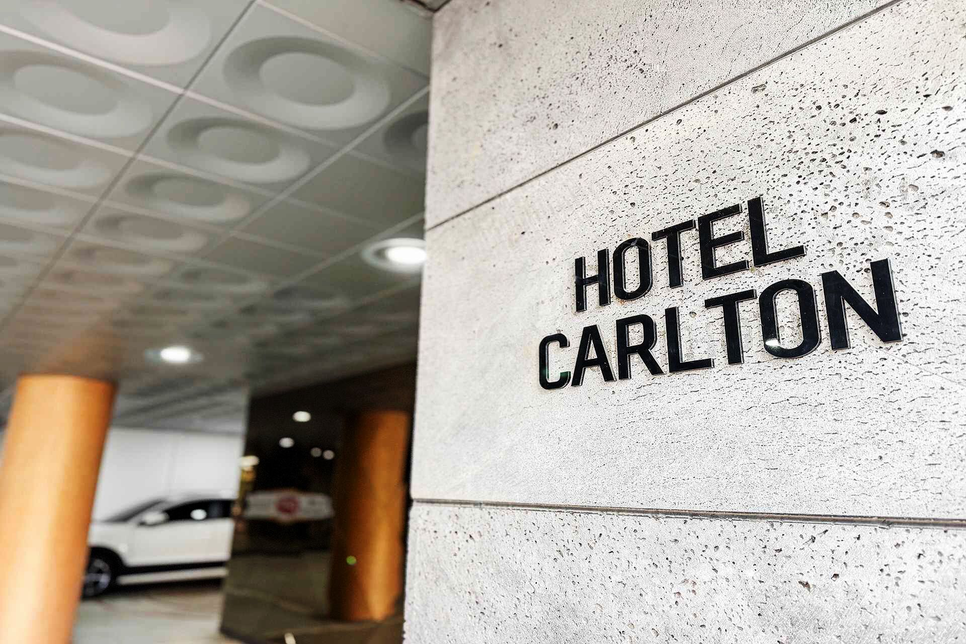 A concrete pillar with the text "HOTEL CARLTON" in bold letters.