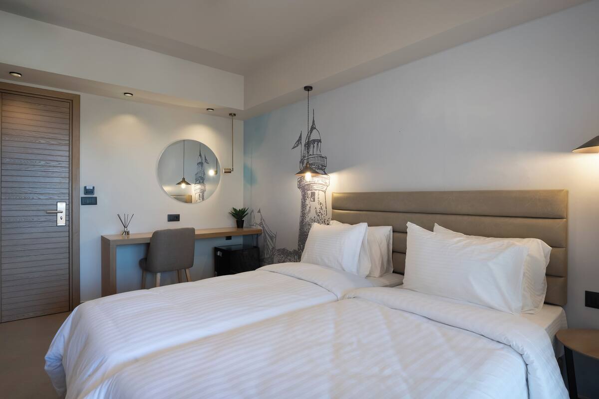 Ein modernes Schlafzimmer mit einem großen Bett, einem Schreibtisch und einem wandmontierten Spiegel.