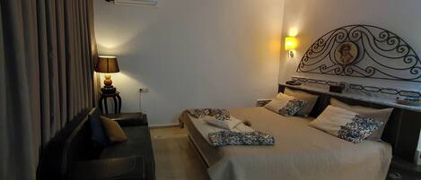 A hotel room with a bed, bedside table, lamp, and curtains.
