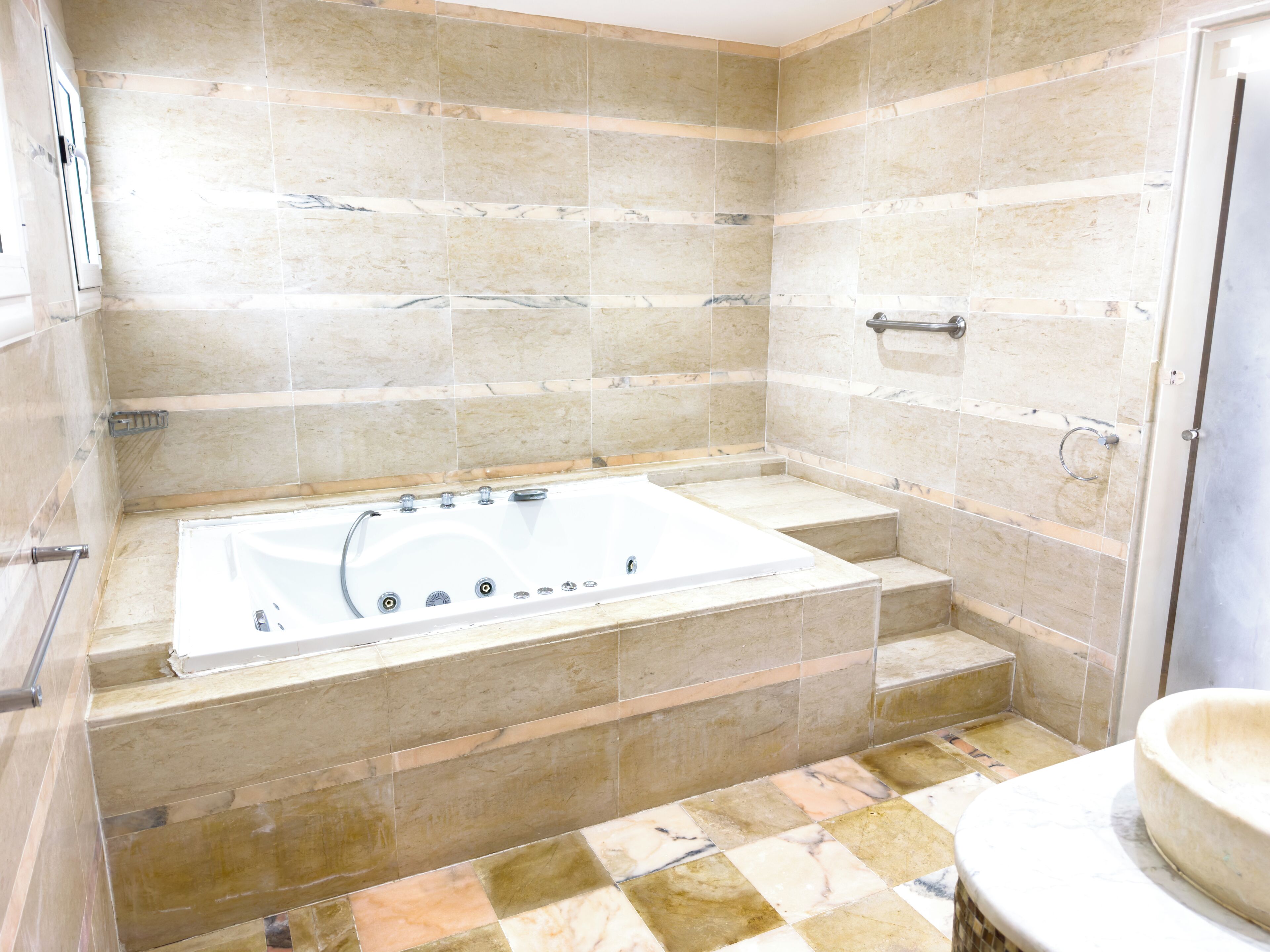 Ein Badezimmer mit Badewanne, gefliesten Wänden und Toilette.