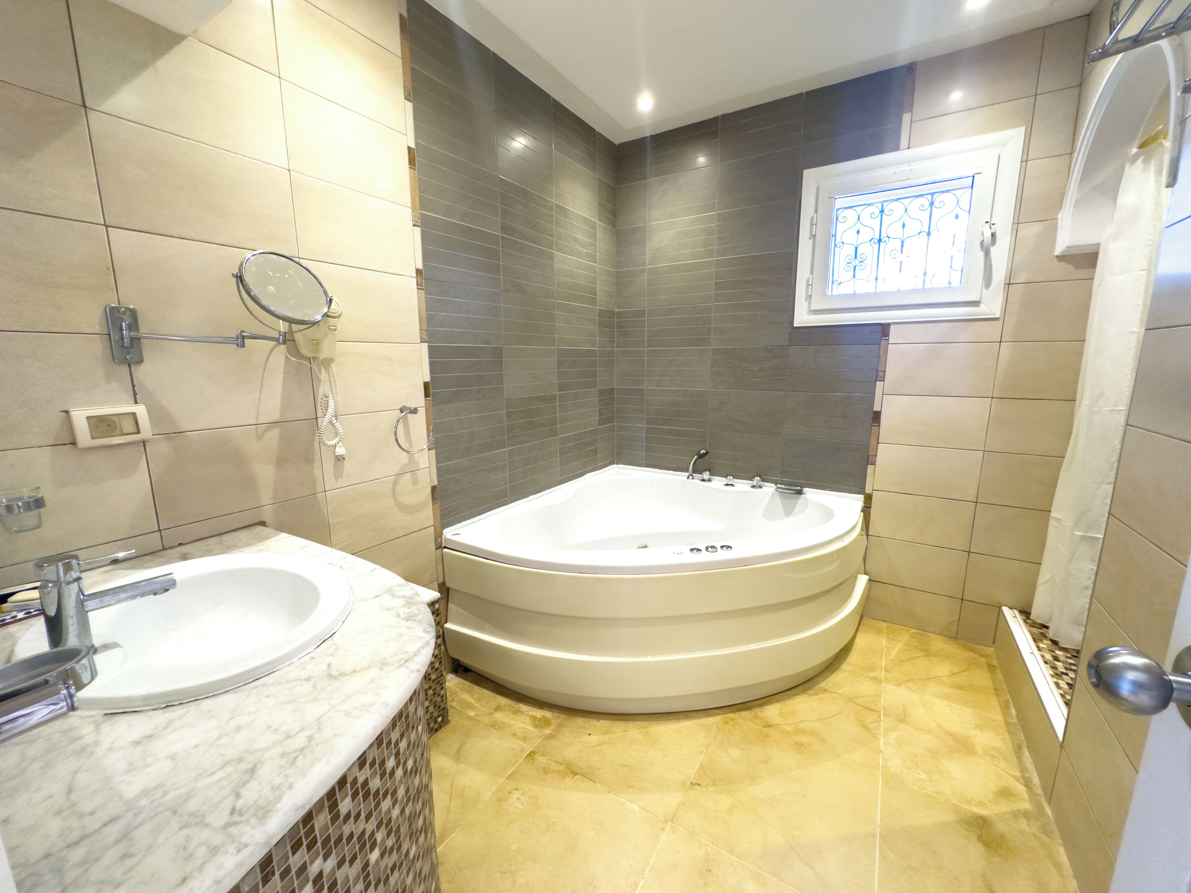 A bathroom with a bathtub, a sink, and a mirror.