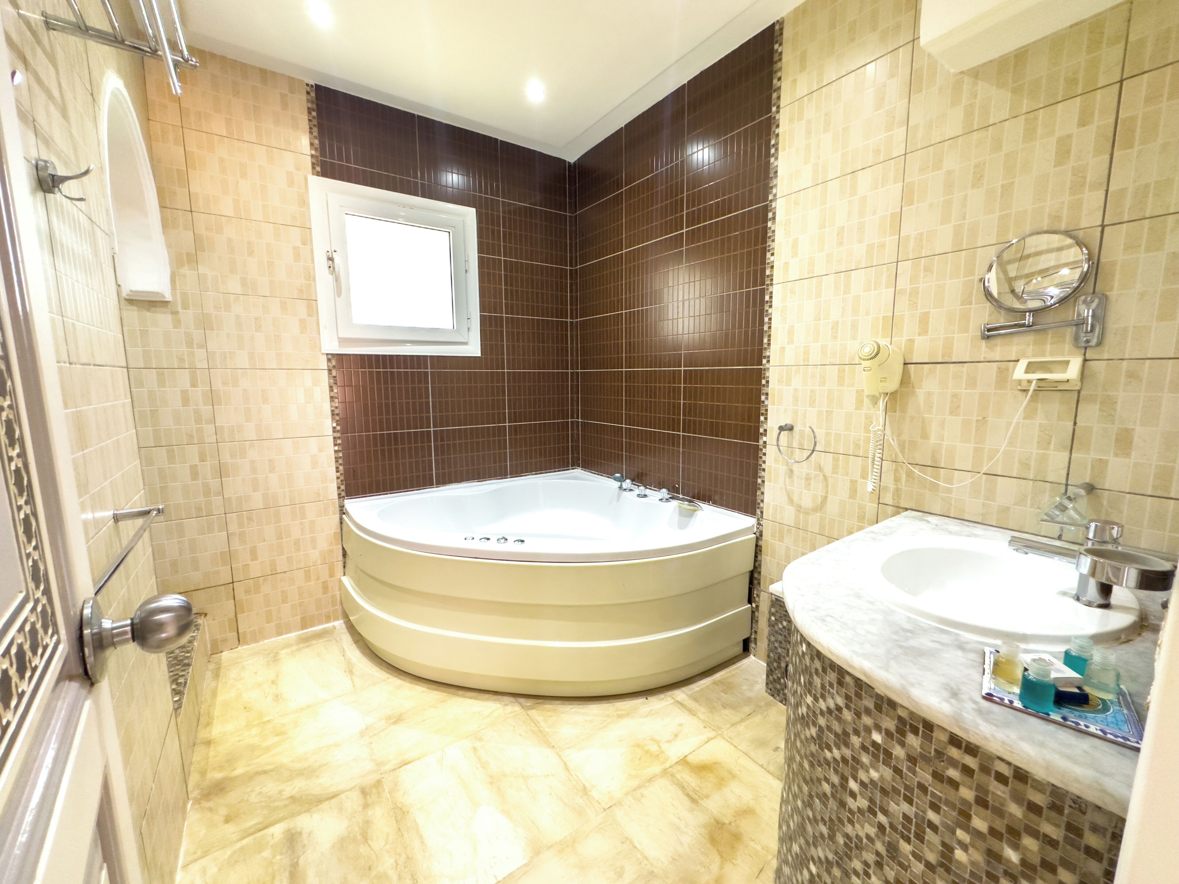 A bathroom with a large bathtub, a sink, and a mirror.