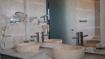 A bathroom with three wooden sinks, a hairdryer, and a telephone.